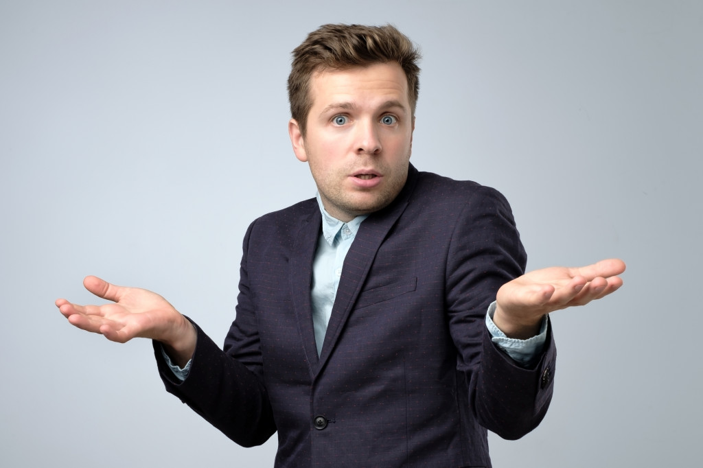 Confused young caucasian man in suit shrugging his shoulders., Strawman Blog image